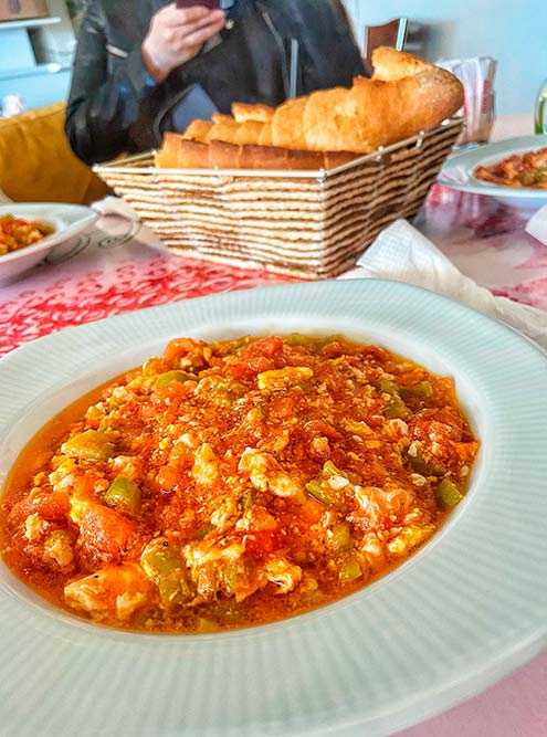 Это менемен — турецкий омлет с овощами и сыром. Идеальное блюдо для завтрака. Для приготовления надо обжарить мелко порезанные лук, перец и тертые помидоры и морковь. После добавить на сковороду взбитые яйца. Главный секрет — постоянно все помешивать. В конце посыпать тертым сыром