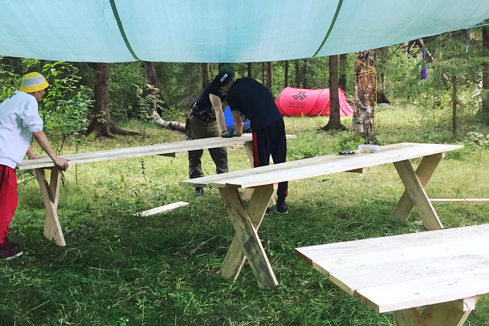 Жених и его друзья собирают столы под тентом