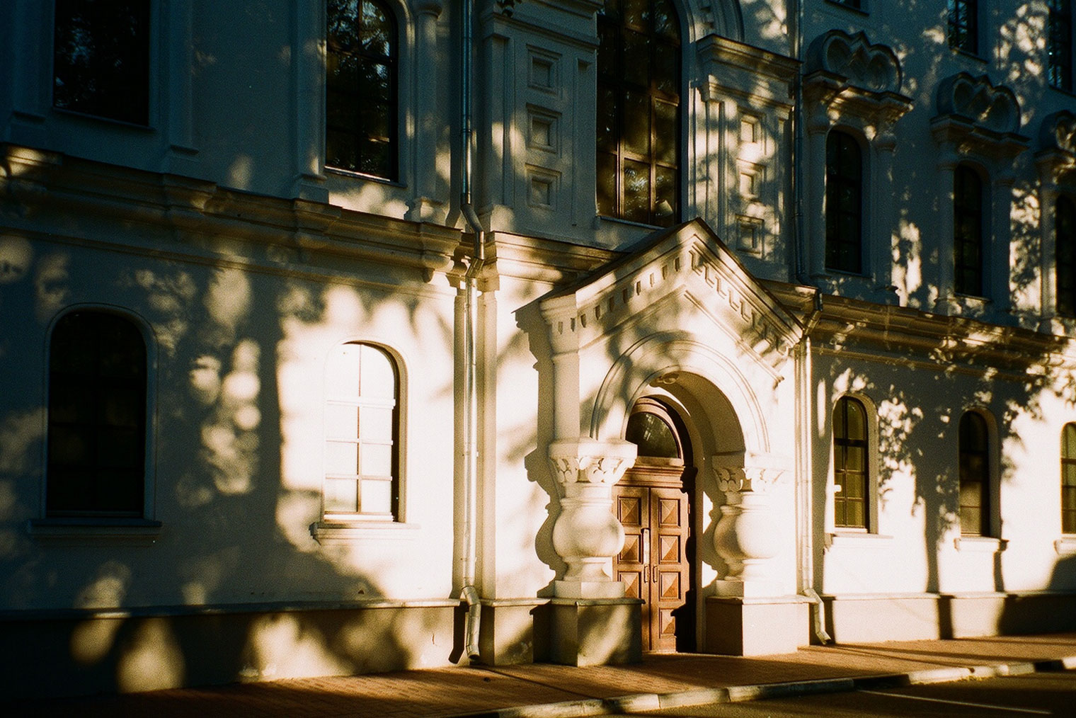 Сняла на пленочный фотоаппарат, как лучи закатного солнца ложатся на здание