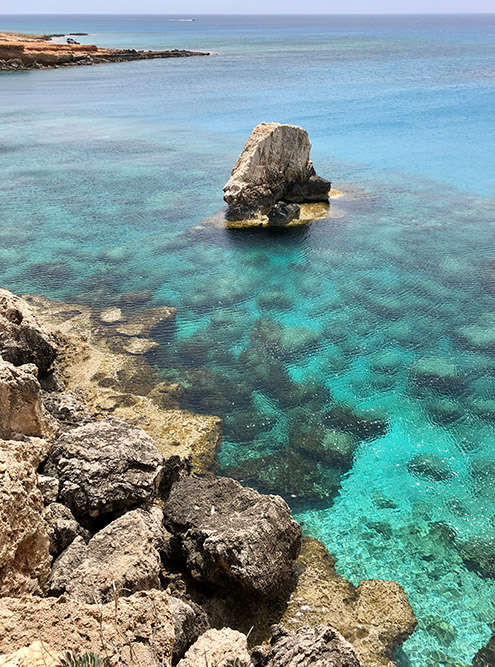 Слева от моста Влюбленных из воды торчит камень