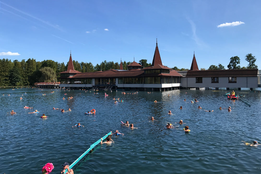 Посетители озера держатся в воде за такие голубые перила или плавают в кругах. Круг можно арендовать на месте или принести свой