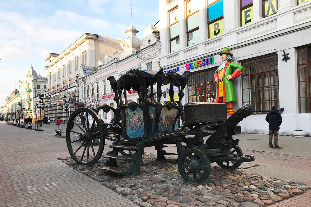 В памятнике карете Екатерины II туристы фотографируются и трогают его на счастье