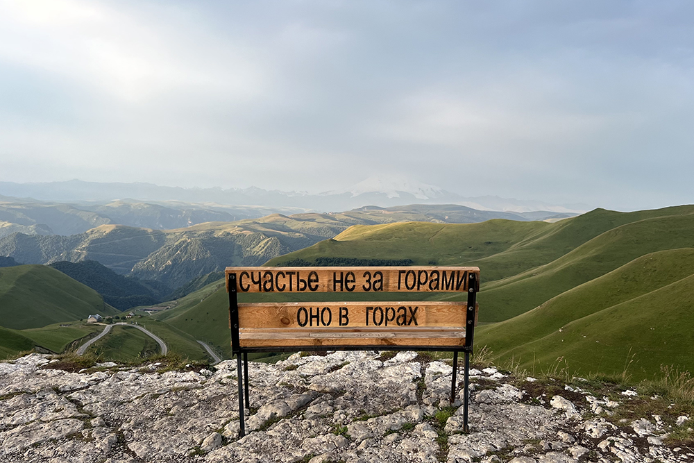 Скамейка на смотровой возле Долины нарзанов подсказывает, что счастье в горах. Но мы это и сами уже поняли