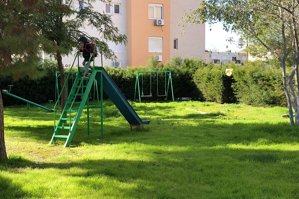 Так выглядит площадка во дворе нашего первого дома. Зеленая трава на Кипре бывает только 3⁠—⁠4 месяца в году, в сезон дождей