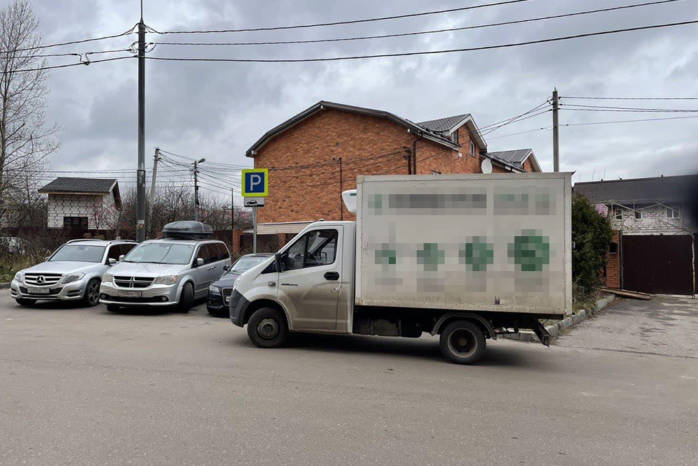 На заднем фоне висит знак с правилами парковки. Эта Газель их явно нарушает