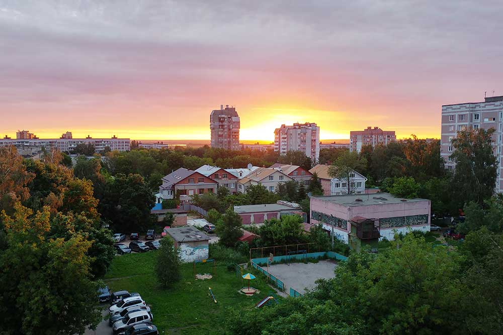 Вид из окна моей квартиры на восходе солнца. В поле зрения — перестроенный в коттеджи в 90⁠-⁠е годы детский сад. С левой стороны за деревьями две школы в 5 минутах ходьбы. Вдалеке видна полоска Оки, пока ее еще не загородили новостройки