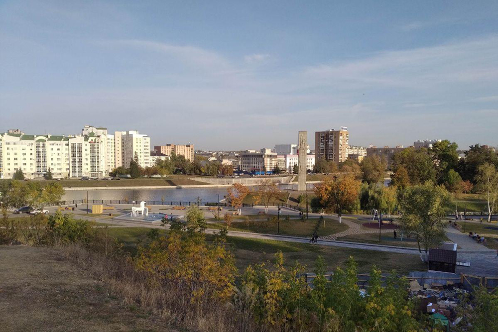 Вид на Детский парк с улицы Пролетарская Гора. Чуть правее — серый столб Стрелки на фоне многоэтажек и универмага