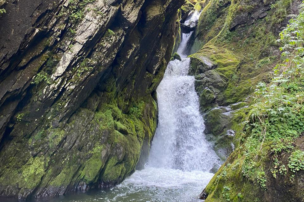 Это водопад Эстюбе. На фото не видно, но ниже находится необычное деревянное сооружение — местная ГЭС